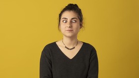 Photo portrait of Squint woman wearing striped t-shirt on yellow background