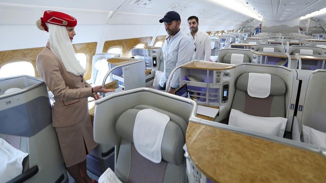 People walk inside of the 100th Emirates Airline double-decker Airbus A380, the worlds largest passenger aircraft, during the 2018 Bahrain International Airshow (BIAS) at the Sakhir Airbase, south of the Bahraini capital Manama on November 14 2018. (