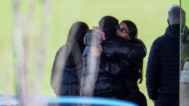 Antonela Roccuzzo, the wife of footballer Lionel Messi, hugs a person at El Prado Cemetery, following the death of Messi's father, Jorge Messi, in Perez, Rosario department, Argentina, August 9, 2026. REUTERS/Agustin Marcarian