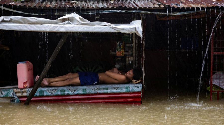 Seorang laki-laki beristirahat saat hujan muson barat daya menggenangi sebuah desa di Bagong Silangan, Kota Quezon, Filipina, 10 Agustus 2026.