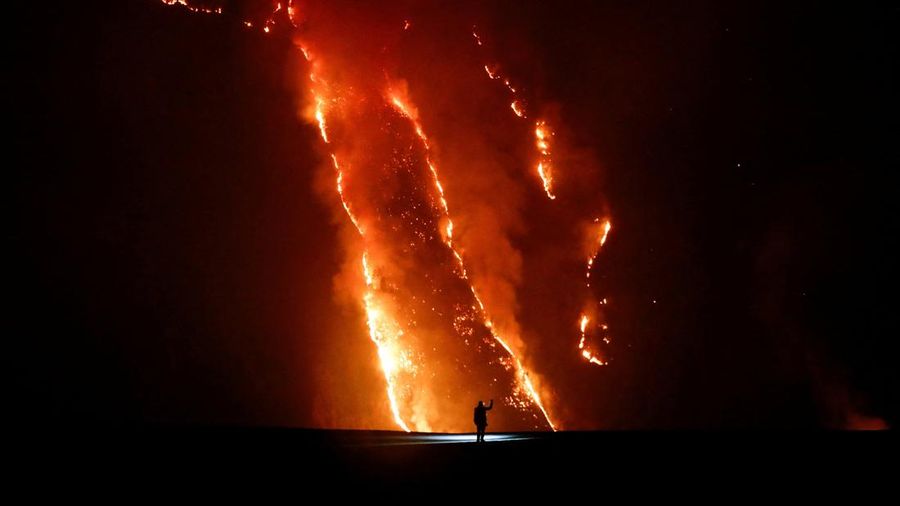 Seseorang mengawasi kobaran api saat kebakaran rimba di lereng bukit di Taman Nasional Bromo Tengger Semeru di Probolinggo, Provinsi Jawa Timur, MInggu (9/8/2026). (REUTERS/Dipta Wahyu)