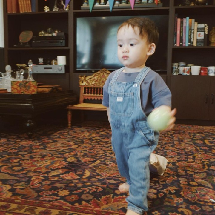 <p>Dalam satu unggahan, Anggika memposting foto Arya yang sudah bisa berjalan. Arya yang mengenakan&nbsp;overall jeans dengan kaus biru tampak sedang menikmati perayaan ulang tahunnya. (Foto: Instagram @anggikabolsterli)</p>