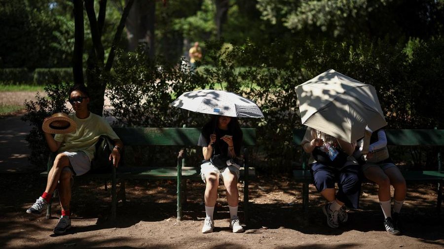 Orang-orang duduk di tempat teduh saat mengunjungi Forum Romawi di tengah suhu nan mendekati 40 derajat Celsius akibat gelombang panas, di Roma, Italia, 11 Agustus 2026.