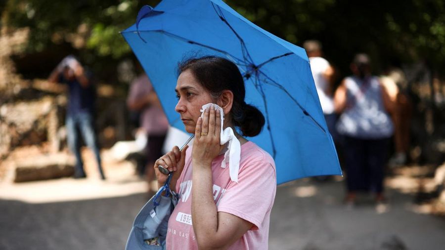 Seorang wanita menyeka keringat dari wajahnya saat mengunjungi Forum Romawi di tengah suhu nan mendekati 40 derajat Celsius akibat gelombang panas, di Roma, Italia, 11 Agustus 2026.