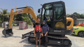 Pasangan asal Grobogan, Rico Putra Roberto Syah (23) dan Laella Nur Fadhilah (20) berfoto di depan ekskavator mahar pernikahan.