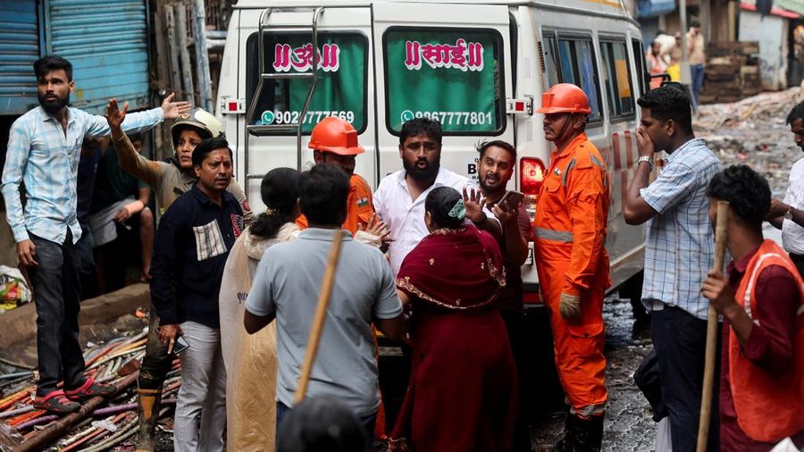 Anggota family dari seorang korban meninggal menunggu untuk masuk ke dalam ambulans setelah terjadi tanah longsor, menyusul runtuhnya sebagian bukit nan menimpa rumah-rumah di area permukiman padat masyarakat di Mumbai, India, pada 12 Agustus 2026.