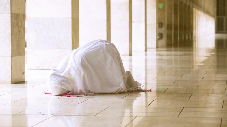 Muslim woman wearing prayer veil&comma; doing prostration in the mosque