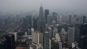 The Petronas Twin Towers (C) are covered in haze in Kuala Lumpur on August 11, 2026, as authorities in Malaysia warned of high levels of air pollution from regional wildfires. The Malaysian Meteorological Department urged people on August 11 affected