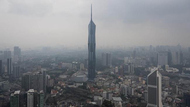 Warisan Merdeka Tower (KL118) (C) and commercial buildings are covered in haze in Kuala Lumpur on August 11, 2026, as authorities in Malaysia warned of high levels of air pollution from regional wildfires. The Malaysian Meteorological Department urge