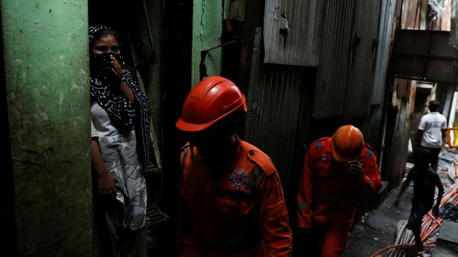 Petugas Pasukan Tanggap Bencana Nasional (NDRF) melangkah menuju letak tanah longsor setelah sebagian bukit runtuh menimpa rumah-rumah di area permukiman kumuh di Mumbai, India, pada 12 Agustus 2026.