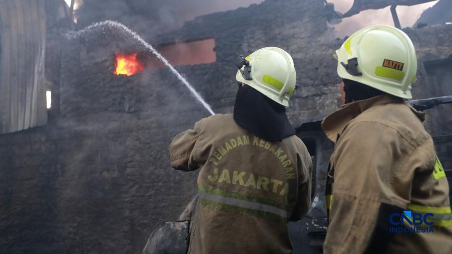 Sejumlah petugas pemadam kebakaran berupaya memadamkan api di sebuah pabrik bingkai nan terbakar, di Jalan Lampiri, Jakarta Timur, Rabu (12/08/2026). (CNBC Indonesia/Muhammad Sabki)
