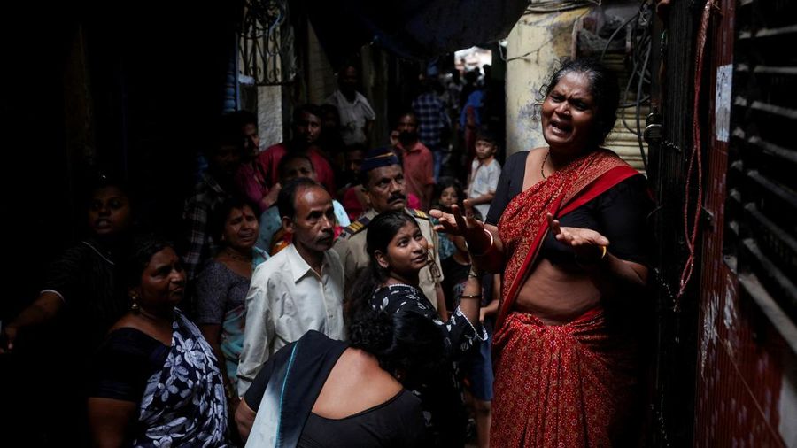 Seorang wanita meratapi kematian putranya akibat tanah longsor setelah sebagian bukit runtuh menimpa rumah-rumah di area permukiman kumuh di Mumbai, India, pada 12 Agustus 2026.