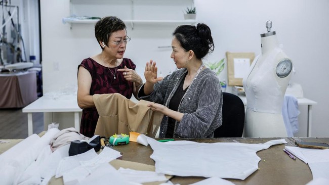 Seamstress Angie Huang and bridal gown pattern maker Tiffany Lin discuss a gown at the Jenny Yoo bridal boutique in New York City, U.S., August 6, 2026. REUTERS/Jeenah Moon
