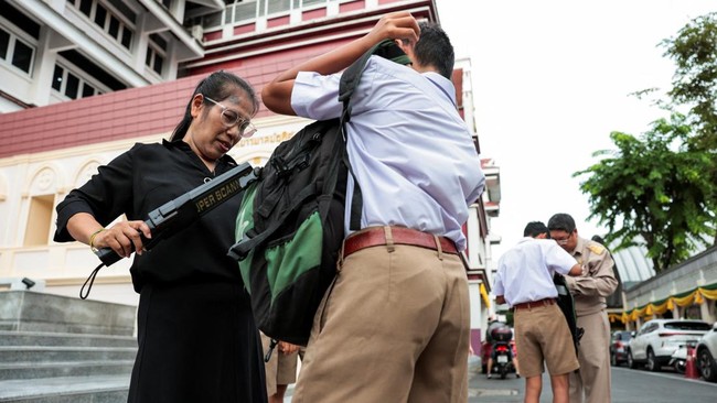 Teachers use metal detectors to screen for weapons and check students' bags as they enter a school in Bangkok, following a deadly shooting at Debsirin Nonthaburi School in Nonthaburi province on the outskirts of Bangkok, Thailand, August 10, 2026. RE