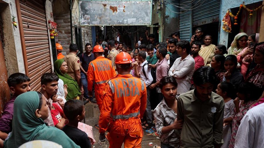 Warga menyaksikan petugas Pasukan Tanggap Bencana Nasional (NDRF) melangkah menuju letak tanah longsor setelah sebagian bukit runtuh menimpa rumah-rumah di area permukiman kumuh di Mumbai, India, pada 12 Agustus 2026. (REUTERS/Francis Mascarenhas)