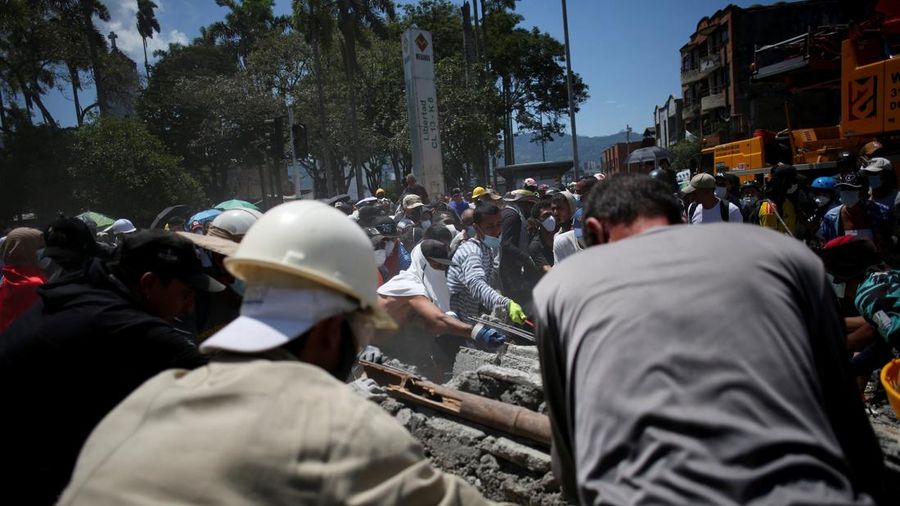 Warga sedang membersihkan puing-puing pascagempa bumi di Pereira, Kolombia, Selasa (11/8/2026). (REUTERS/Juan David Duque)