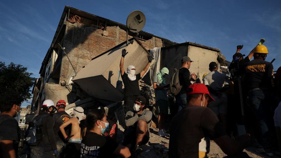 Warga sedang membersihkan puing-puing pascagempa bumi di Pereira, Kolombia, Selasa (11/8/2026). (REUTERS/Luisa Gonzalez)