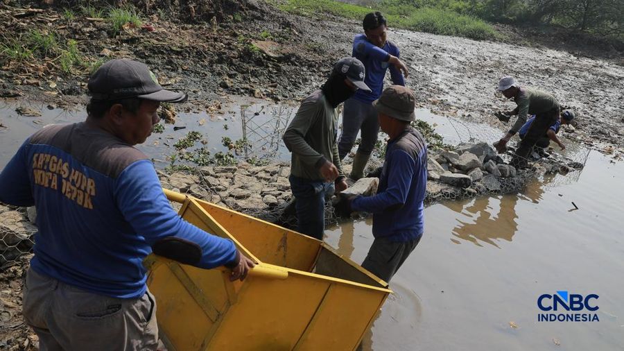 Petugas Satgas SDA PUPR kota depok memasang bronjong batu kali di letak jejak banjir nan sekarang sudah mengering di Jalan penghubung Kampung Bulak, Cipayung, Depok, Jawa Barat, Kamis, (13/8/2026).