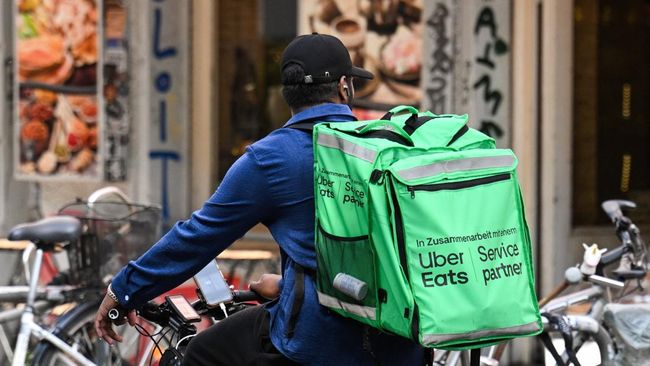 Seorang pengendara sepeda pengantar makanan dengan tas punggung Uber Eats mengendarai sepeda di Berlin, Jerman, pada 16 Juli 2026. (REUTERS/Annegret Hilse)