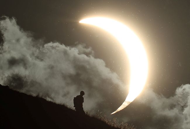 Seseorang menyaksikan gerhana matahari sebagian di Glastonbury Tor, Glastonbury, Inggris, pada 12 Agustus 2026.