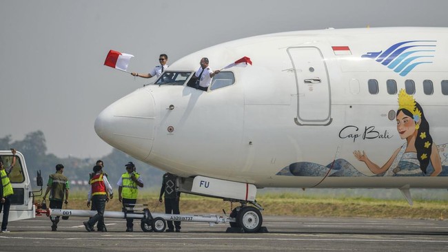 Pilot pesawat Boeing 737-800 milik maskapai Garuda Indonesia mengibarkan bendera Merah Putih saat mendarat di Bandara Husein Sastranegara, Bandung, Jawa Barat, Jumat (14/8/2026). PT Angkasa Pura Indonesia (Persero) kembali melayani penerbangan komers