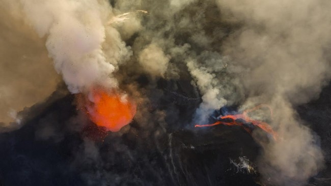 A drone view shows lava being ejected from a crater and molten lava flowing nearby amid volcanic fumes during an eruption of Mount Etna, in Sicily, Italy, August 13, 2026. REUTERS/Giuseppe Di Stefano