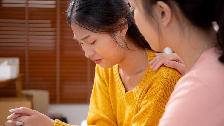 Young asian woman comforting friend with crying and depression sitting on sofa in living room&comma; distress and empathy with friendship&comma; hopelessness and mental health while woman encourage friend&period;