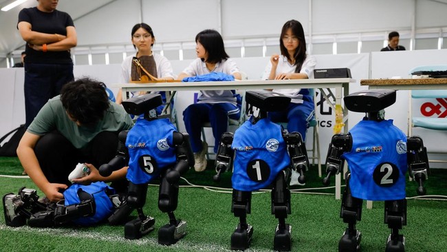 A team member works with a humanoid robot during a training session as part of a media tour, ahead of the 2026 World Humanoid Robot Games, in Beijing, China, August 14, 2026. REUTERS/Maxim Shemetov