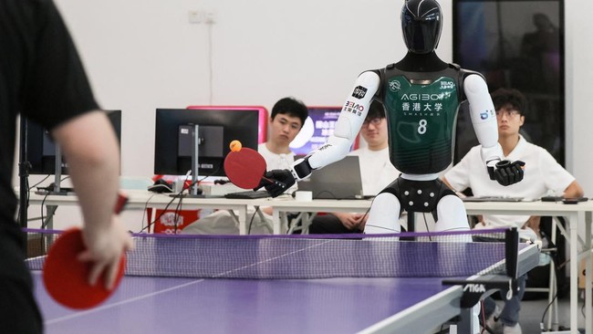 An Agibot humanoid robot plays table tennis with a man during a training session as part of a media tour, ahead of the 2026 World Humanoid Robot Games, in Beijing, China, August 14, 2026. REUTERS/Maxim Shemetov