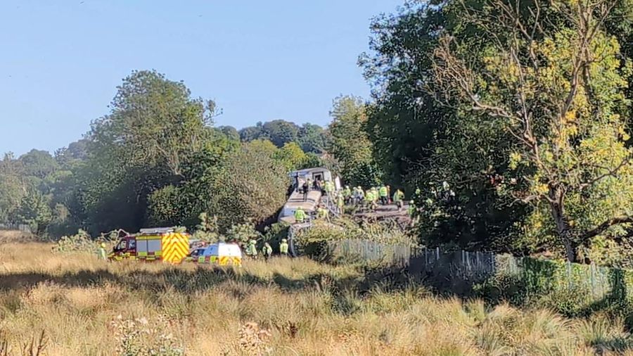 Petugas darurat bekerja di letak kejadian di samping kereta nan terguling setelah kereta penumpang jasa Southern tergelincir di dekat Lewes, Inggris tenggara, Kamis (13/8/2026). (X/via REUTERS)