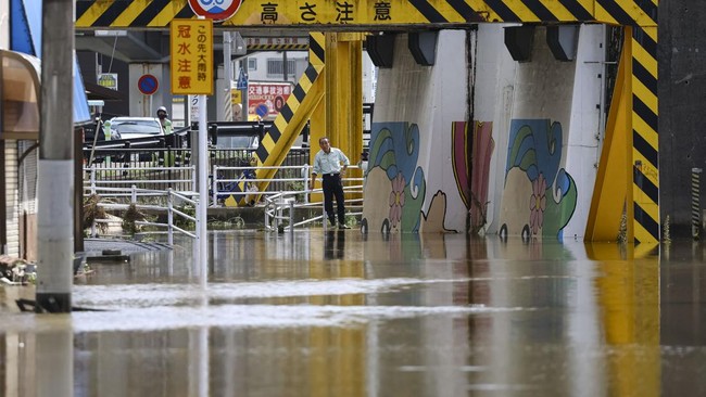 Local residents look at a flooded area after heavy rain in Oamishirasato, Chiba Prefecture, Japan, August 14, 2026. REUTERS/Issei Kato