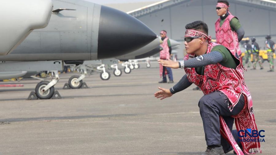 Marshaller pesawat memberikan aba-aba visual terstandarisasi kepada pilot sebelum lepas landas saat latihan demo Udara untuk memperingati HUT ke-81 RI di Terminal Selatan Lanud Halim Perdanakusuma, Jakarta, Sabtu, (15/8/2026). (CNBC Indonesia/Muhamm