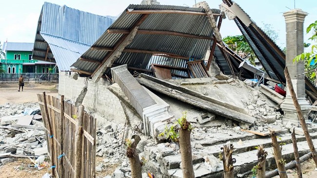A person walks near a heavily-damaged house after an earthquake felt in Nanga Mbaur village, East Manggarai, East Nusa Tenggara province, Indonesia, August 16, 2026. REUTERS/Gabrin Anggur