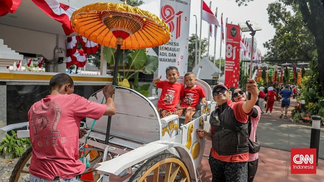 Sejumlah warga mengunjungi Taman Polkam Merdeka 81 di depan Kantor Kemenko Polkam RI, Jakarta, Minggu (16/8). (CNN Indonesia/Febria Adha L)