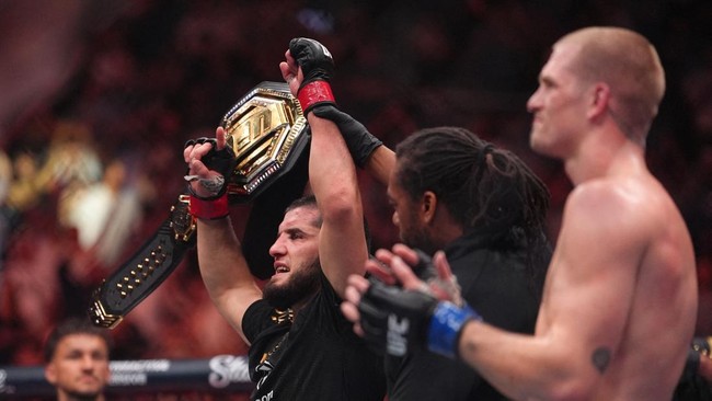 Aug 15, 2026; Philadelphia, Pennsylvania, USA; Islam Makhachev (red gloves) celebrates after defeating Iah Machado Garry (blue gloves) in the welterweight title bout during UFC 330 at Xfinity Mobile Arena. Mandatory Credit: Kyle Ross-Imagn Images