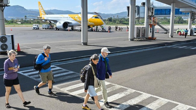 Sejumlah penumpang pesawat berjalan setibanya di Bandara Komodo, Manggarai Barat, NTT, Minggu (16/8/2026). Operasional penerbangan di bandara tersebut tetap berjalan secara normal dengan pembatasan pascagempa bumi bermagnitudo 7,7 di wilayah NTT pada
