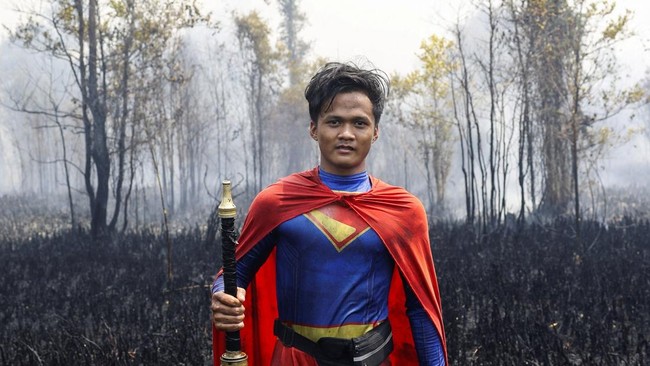 Rudiyansah, 16, wearing a Superman costume poses for a photograph after extinguishing a fire at a wildfire-affected area in Palangka Raya, Central Kalimantan province, Indonesia, August 14, 2026. REUTERS/Ajeng Dinar Ulfiana REFILE - UPDATING GRAMMAR