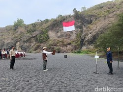 Bendera Raksasa Berkibar di Tebing Pantai Dampar Lumajang