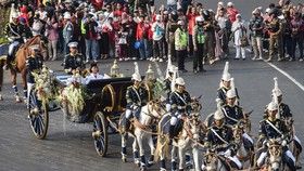 Purna Paskibraka Duta Pancasila 2025 Bianca Sultana Najwa (kanan) dan Aliah Sakira (kiri) membawa bendera pusaka dan naskah Proklamasi di atas kereta kencana Garuda Prabayaksa dari Monumen Nasional menuju Istana Merdeka dalam Kirab Merah Putih di Jak