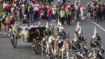 Purna Paskibraka Duta Pancasila 2025 Bianca Sultana Najwa (kanan) dan Aliah Sakira (kiri) membawa bendera pusaka dan naskah Proklamasi di atas kereta kencana Garuda Prabayaksa dari Monumen Nasional menuju Istana Merdeka dalam Kirab Merah Putih di Jak