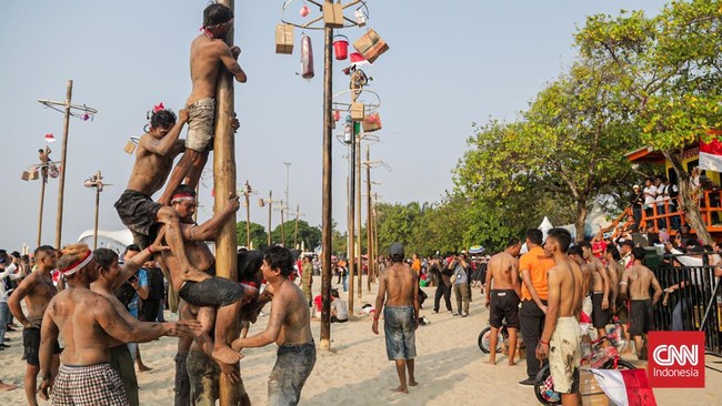 Sejumlah peserta mengikuti lomba panjat pinang kolosal di Beachpool, Ancol, Jakarta Utara, Senin (17/8). (CNN Indonesia/Febria Adha L)