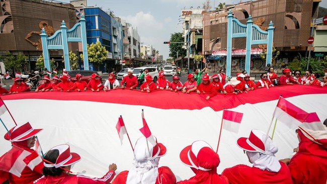 Warga membentangkan bendera merah putih berukuran besar saat di Ngarsapura, Solo, Jawa Tengah, Senin (17/8/2026). Pembentangan bendera merah putih berukuran 9x14 meter di tengah jalan tersebut dalam rangka peringatan detik-detik HUT Kemerdekaan ke-81