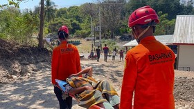 This handout picture taken and released on August 16, 2026 by Indonesia's National Search and Rescue Agency (BASARNAS) shows rescuers evacuating a villager on a stretcher on Indonesia's eastern Flores island, East Nusa Tenggara, a day after a magnitu