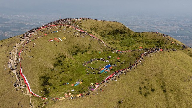 Foto udara sejumlah pendaki membentangkan bendera saat HUT Kemerdekaan ke-81 Republik Indonesia di Puncak Pawitra Gunung Penanggunan, Mojokerto, Jawa Timur, Senin (17/8/2026). Kegiatan yang membentangkan bendera sepanjang 1000 meter dan upacara pengi