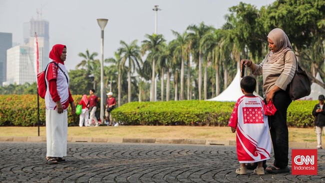 Sejumlah warga menghadiri perayaan HUT ke-81 RI di area Monas, Jakarta, Senin (17/8). (CNN Indonesia/Febria Adha L)