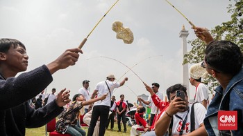 Sejumlah warga menghadiri perayaan HUT ke-81 RI di area Monas, Jakarta, Senin (17/8). (CNN Indonesia/Febria Adha L)