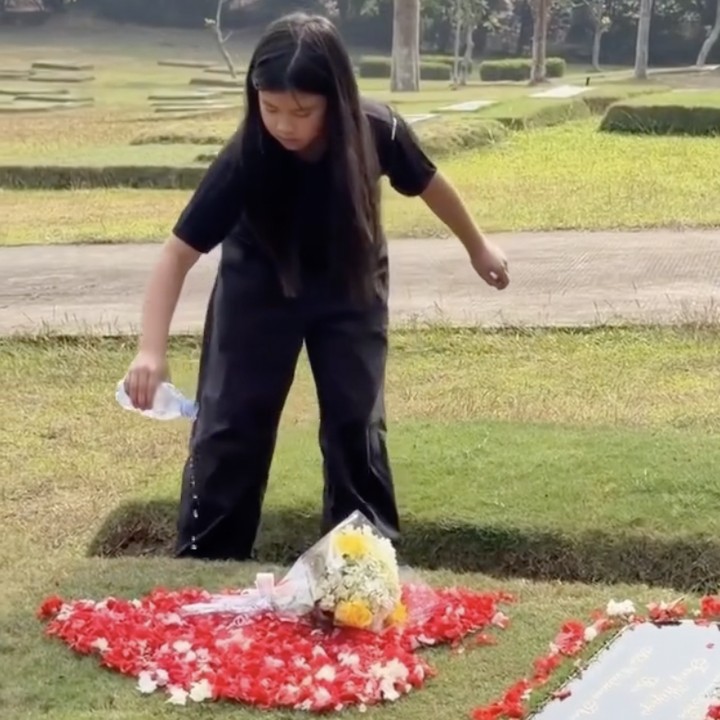 <p>Bocah perempuan berusia 9 tahun ini nampak menaburkan bunga mawar merah yang dibentuk love dan menuang air ke atas makam sang ayah. Ia nampak begitu menghayati momen tersebut, Bunda. (Foto: Instagram @ibnujamilo)</p>