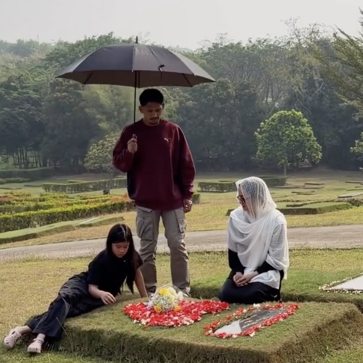 <p>Sebagai ayah sambung, Ibnu Jamil nampak ikut mendampingi Yaya dan Ririn dalam ziarah tersebut. Ia nampak memayungi Yaya yang terlihat tengah asik mengunjungi 'rumah baru' mendiang ayahnya. (Foto: Instagram @ibnujamilo)</p>