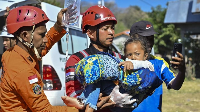 Petugas mengevakuasi korban gempa di Ronting, Lamba Leda, Manggarai Timur, Nusa Tenggara Timur, Selasa (18/8/2026). Basarnas bersama petugas gabungan mengevakuasi sejumlah korban luka menggunakan helikopter ke Labuan Bajo, Manggarai Barat, untuk mend