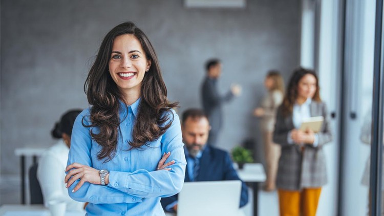 Successful businesswoman standing in creative office and looking at camera&period; Young woman entrepreneur in a coworking space smiling&period; Portrait of beautiful business woman standing in front of business team at modern agency with copy space&period;